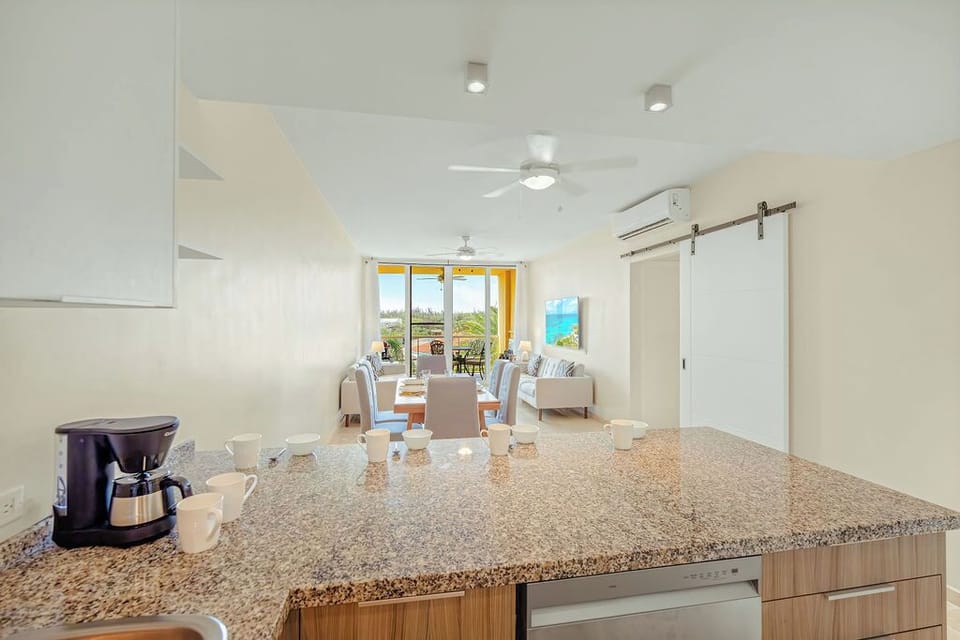 Fully equipped modern kitchen with stainless appliances and bar seating, ideal for cooking and gathering together.