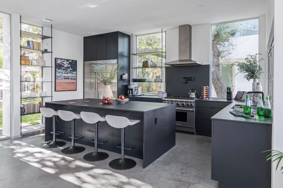 Unit 1304A: Kitchen with barstool and modern appliances.