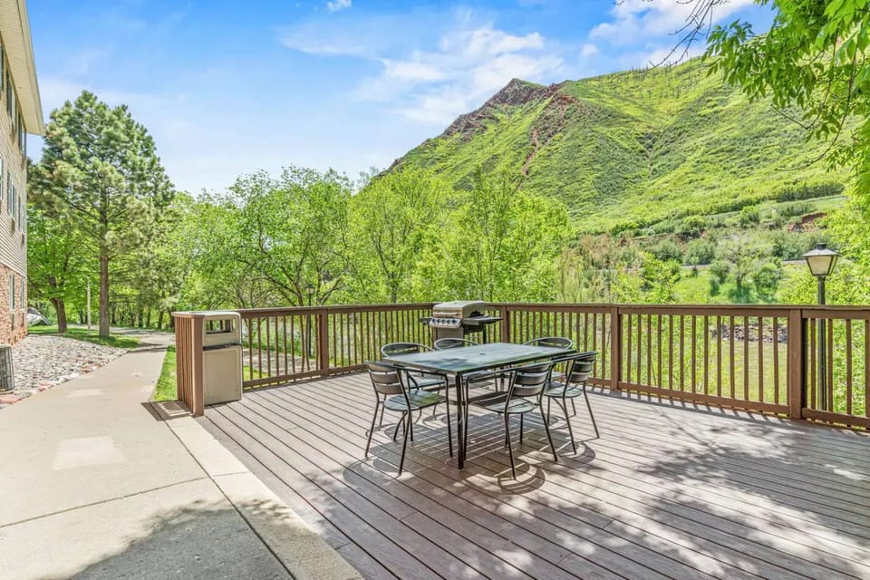 Deck with seating and grill facing scenic mountains and trees