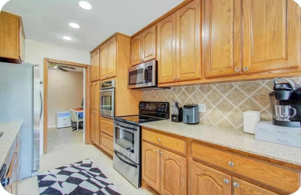 Fully Equipped Kitchen: Prepare meals with ease in our spacious kitchen, featuring modern appliances, a coffee maker, and ample cabinet storage. The open layout and large countertops provide a seamless culinary experience for your group.