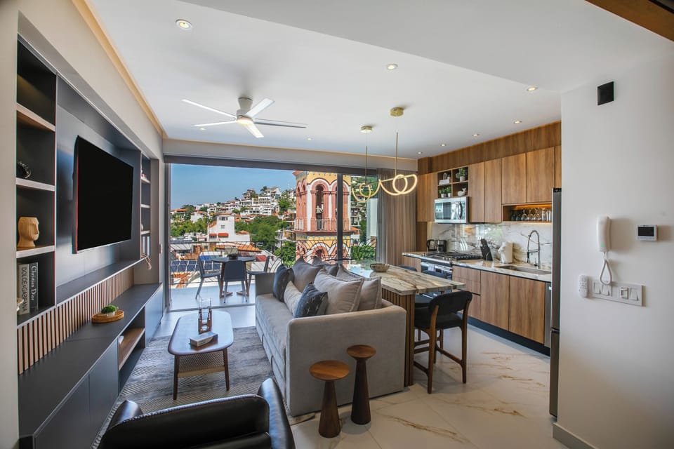Indoor–outdoor living room opening to a furnished terrace with panoramic views