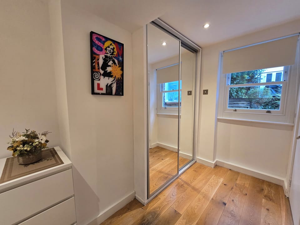 Wardrobe, chest of drawers, tasteful art and window with blackout blind