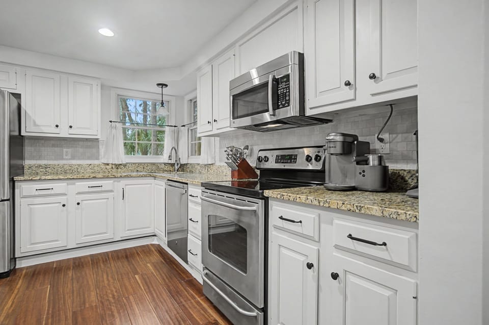 Cook your favorite meals in this bright, fully-equipped kitchen featuring modern stainless appliances, granite countertops, and plenty of cabinet space.