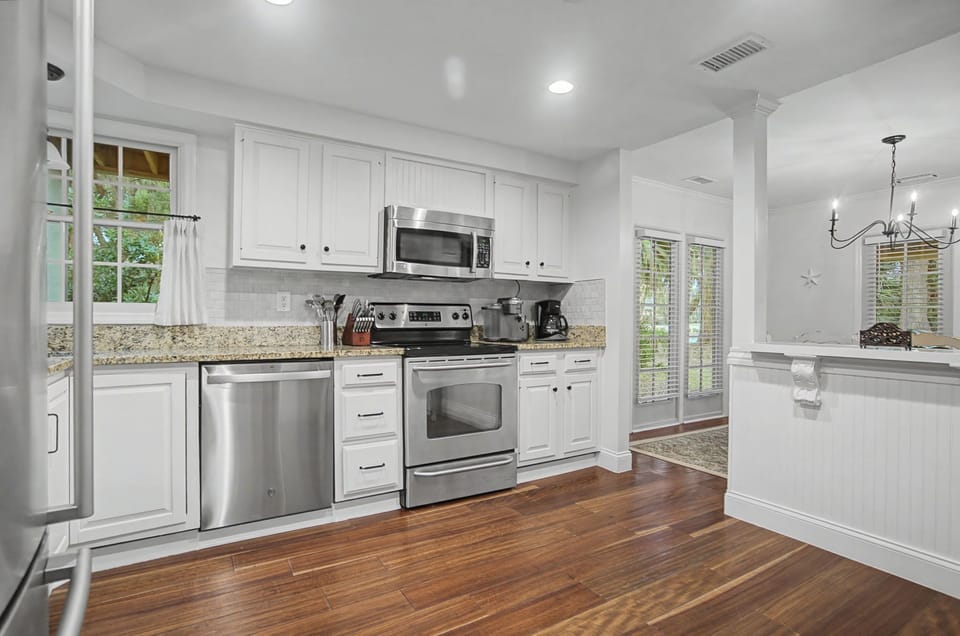 You'll love cooking in this bright, fully-equipped kitchen with granite counters, stainless appliances, and rich hardwood floors.
