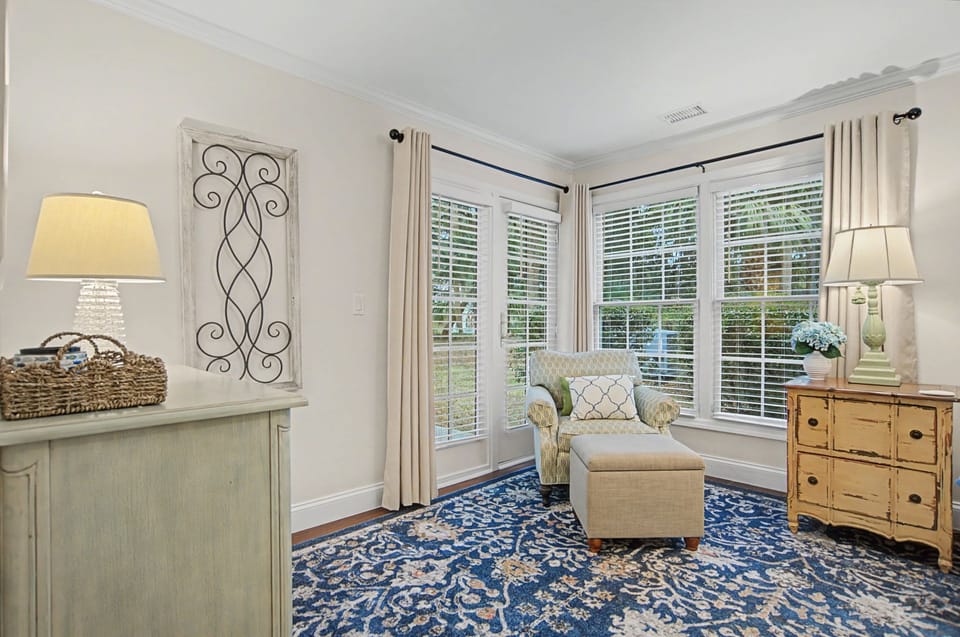 Your cozy reading nook beckons with a plush armchair and ottoman where you can unwind with a book in natural light.