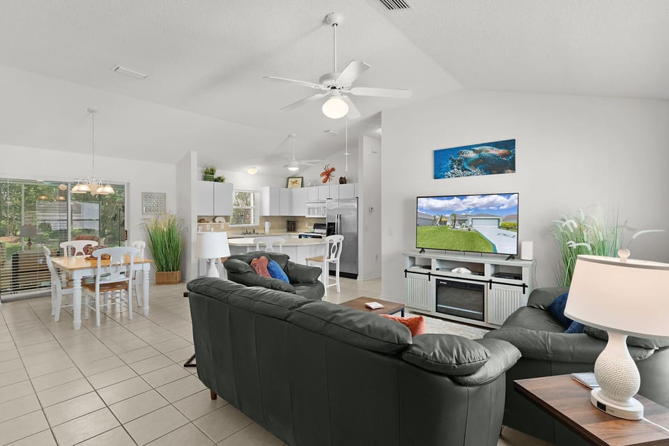 Sink into plush leather seating while you enjoy entertainment in this bright, open living space with modern kitchen nearby.