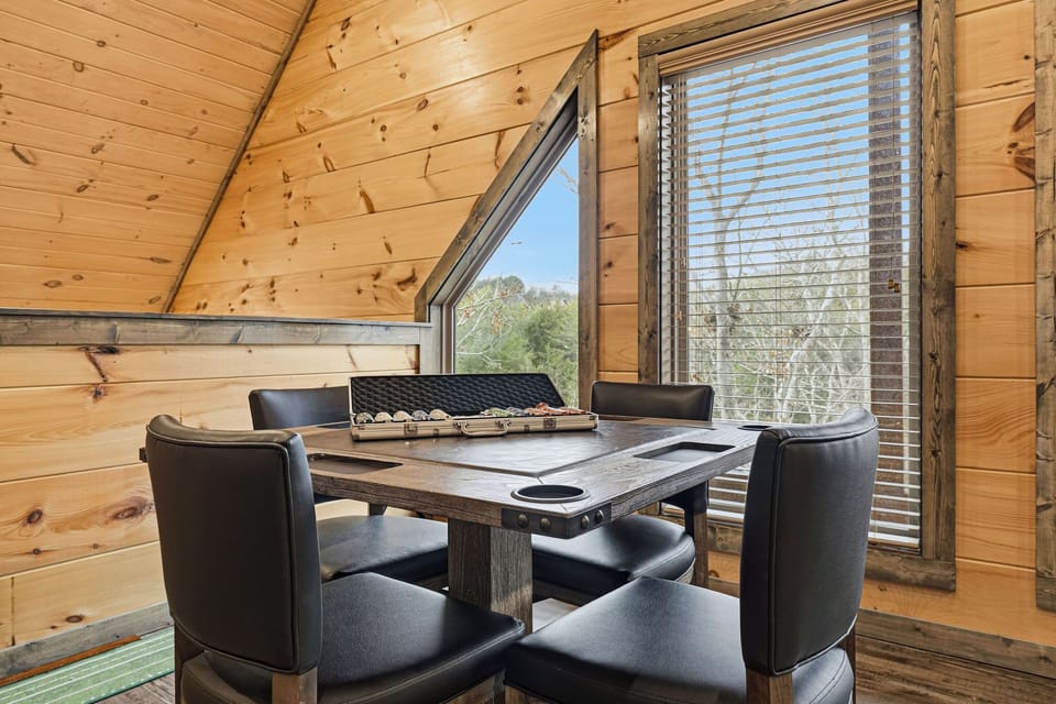 Settle into this cozy wood-lined dining nook where warm timber surrounds you and large windows frame peaceful forest views for memorable meals.
