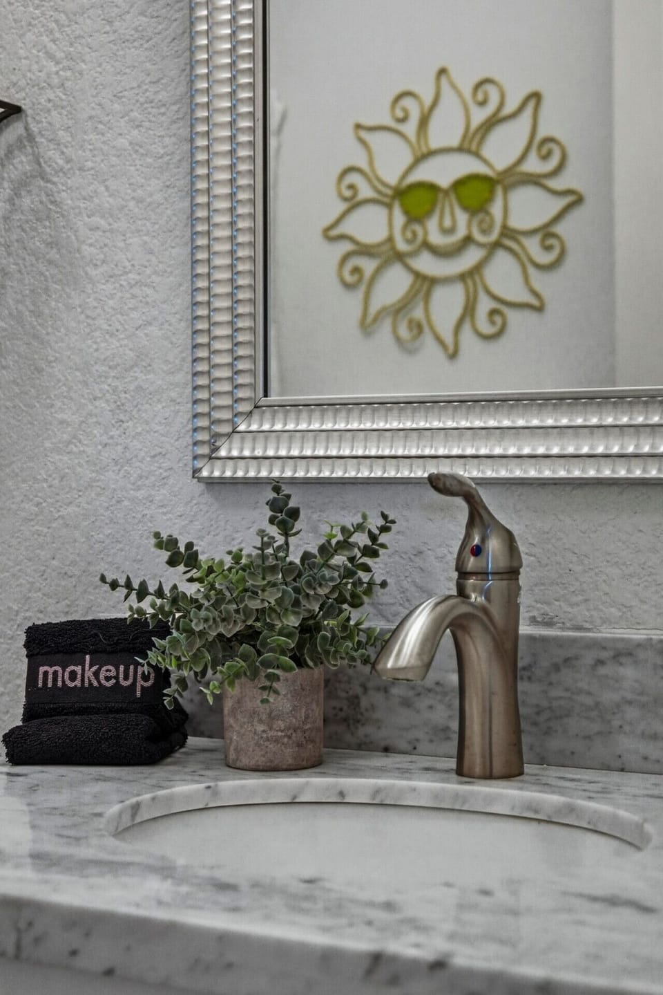 Start your day with a smile—marble vanity, cheerful sun mirror, and plush towels bring a little extra joy to your morning routine.