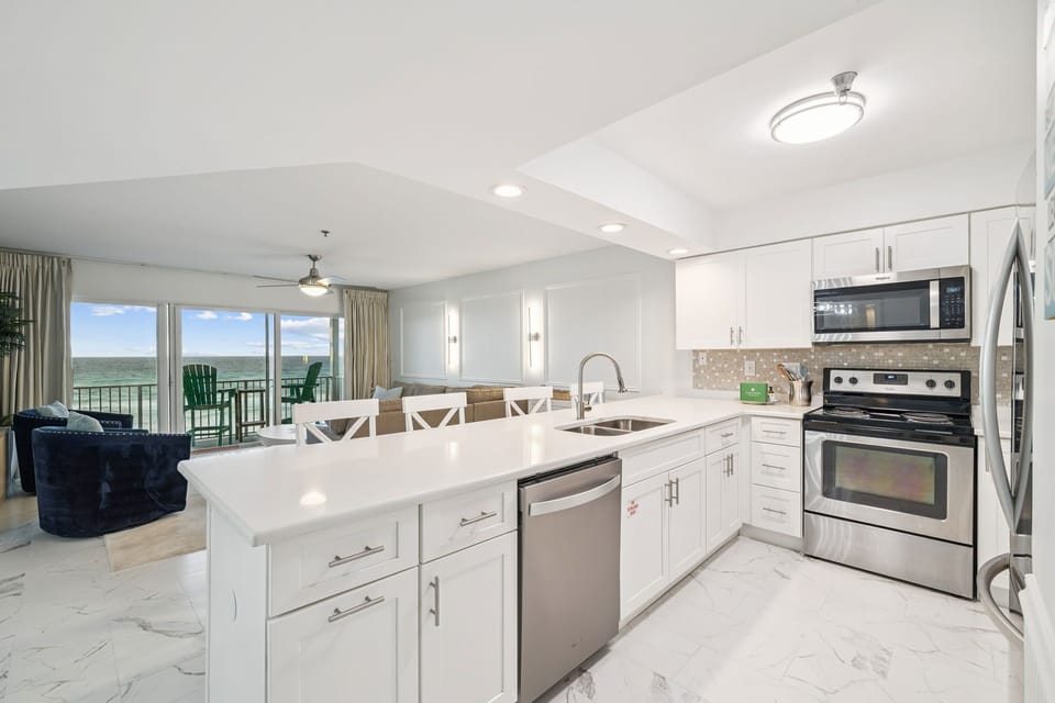 Your modern kitchen opens to stunning water views, with sleek white cabinets, granite counters, and everything needed for memorable meals together.