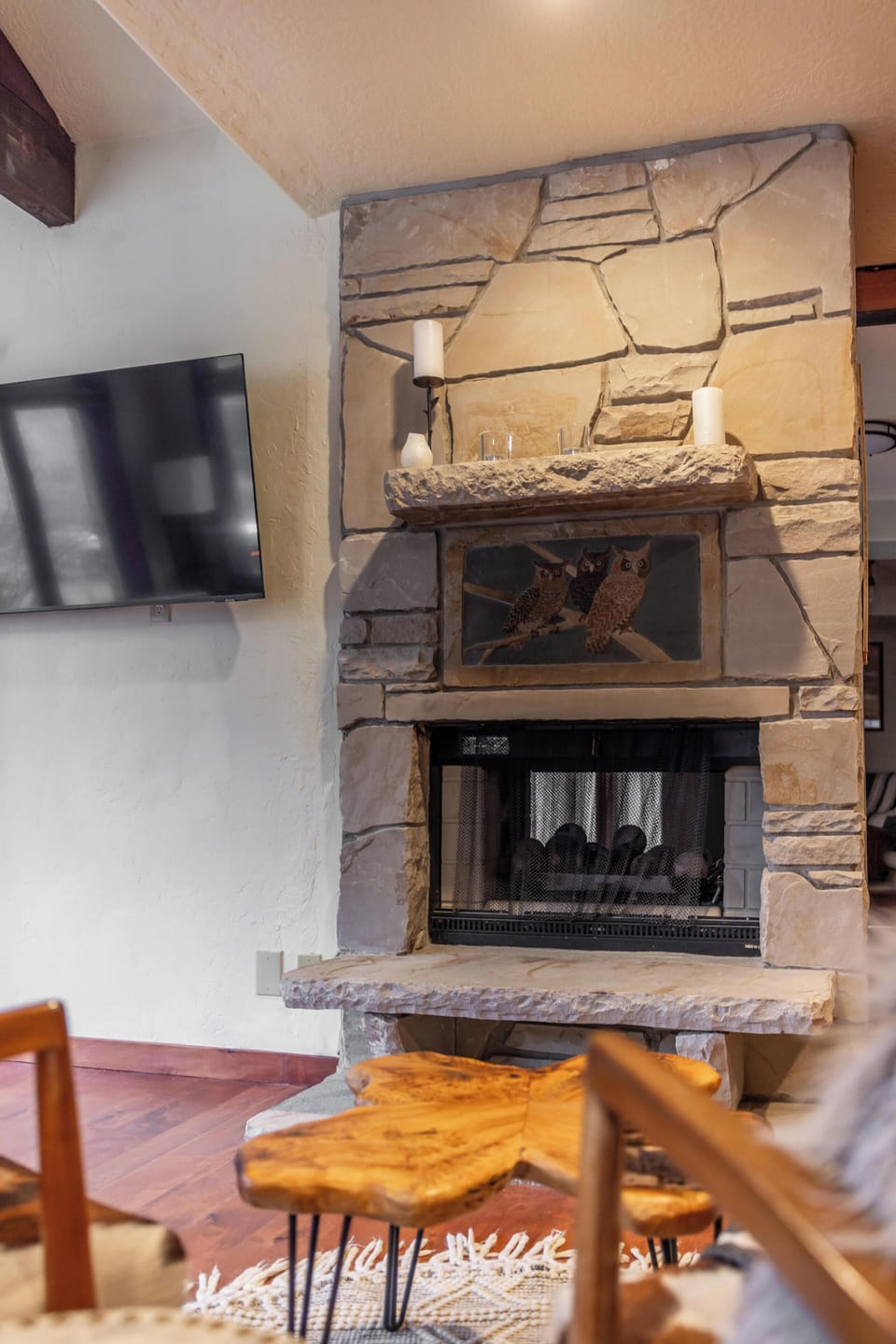 Cozy stone fireplace, vaulted ceilings, and TV—rustic lodge vibes.
