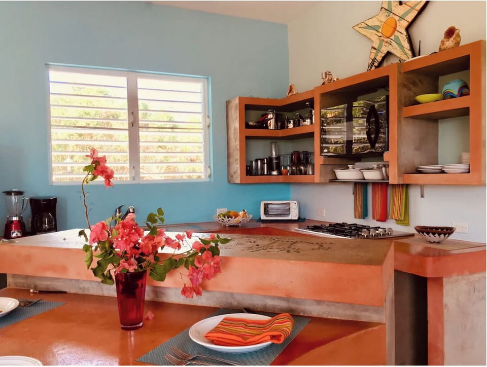 Custom concrete counter top kitchen with microwave, range, and cooking supplies