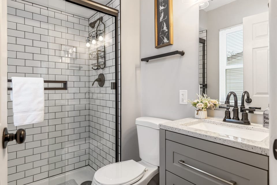 Private en-suite bathroom with a tiled walk-in shower, vanity, mirror, and toilet.