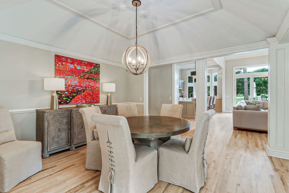 Natural light pours in through oversized windows, highlighting the wide-plank hardwood floors and clean architectural lines.