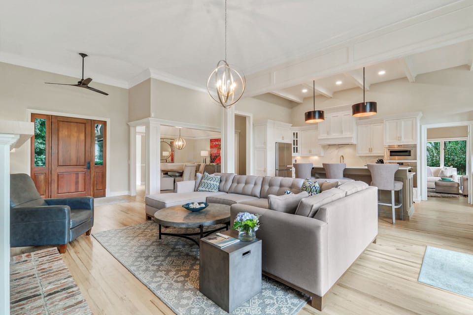 The chef's kitchen features crisp cabinetry, a large island with seating, and thoughtful finishes that keep everything open and welcoming