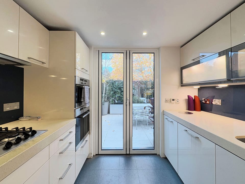 Modern, fully equipped kitchen with fridge freezer, double oven, and dishwasher.