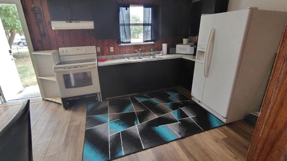 Kitchen with stove, refrigerator, sink, and microwave