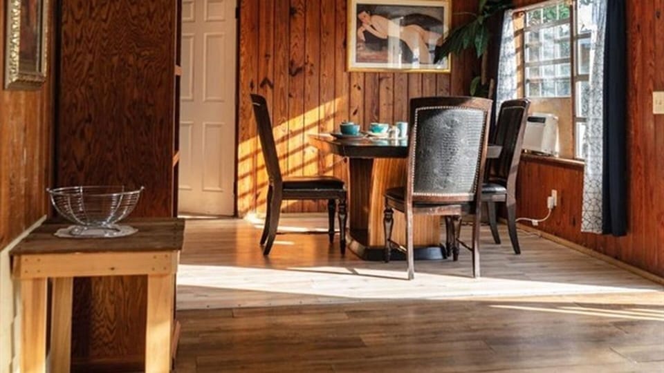 Dining area with natural light and wood-paneled walls
