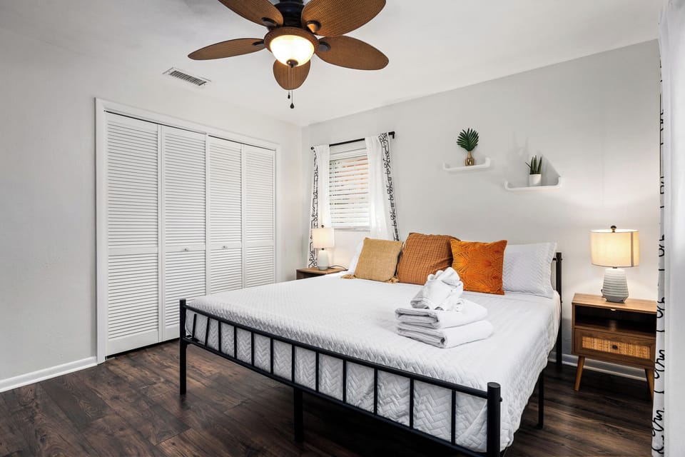 Peaceful bedroom with soft linens and closet storage.