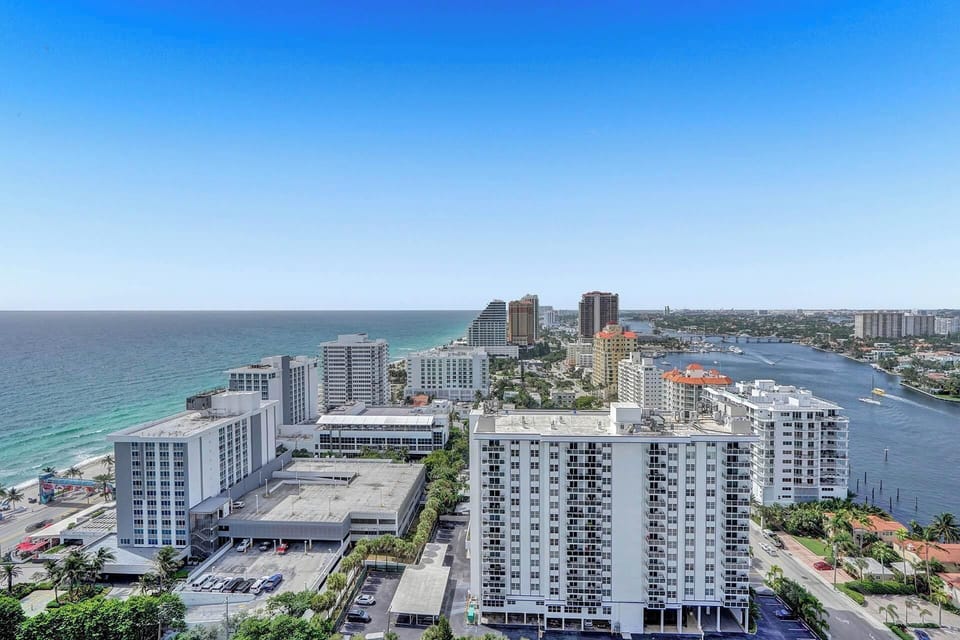 Wide aerial of Fort Lauderdale beach, city skyline and sparkling coastline.