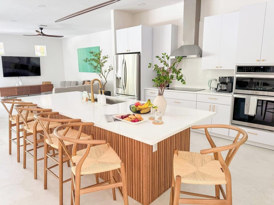 Fully stocked contemporary kitchen with a five-burner electric cooktop.
Pull up to the island to chat, sip, or snack while cooking—it’s where meals and memories happen!