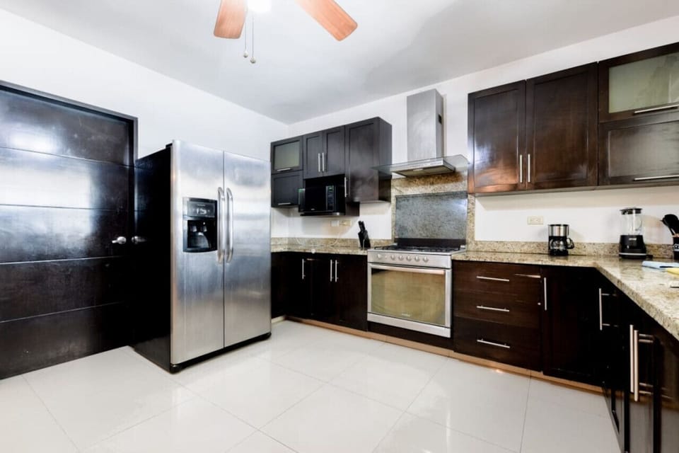 Cocina equipada con refrigerador, estufa y horno de microondas.