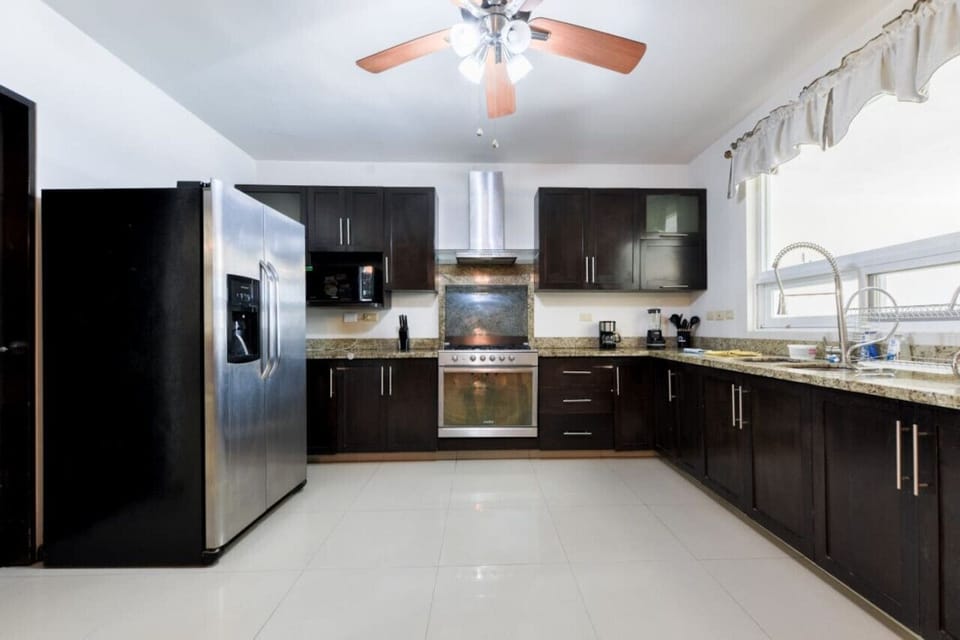 Cocina equipada con refrigerador, estufa y horno de microondas.