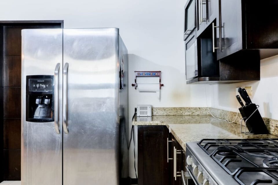 Cocina equipada con refrigerador, estufa y horno de microondas.