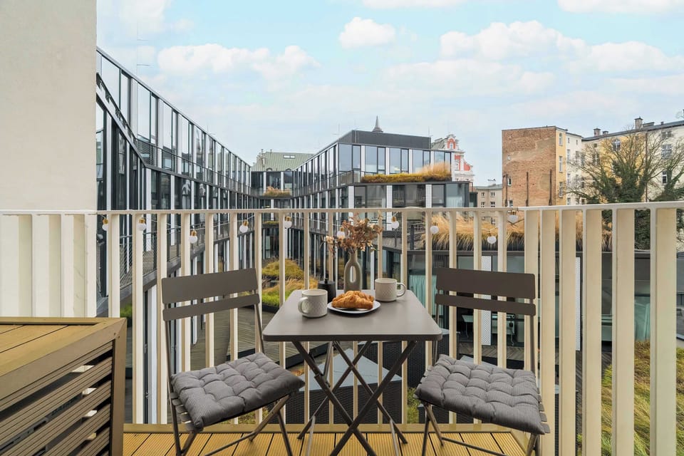 Charming balcony view overlooking a peaceful courtyard with outdoor seating.