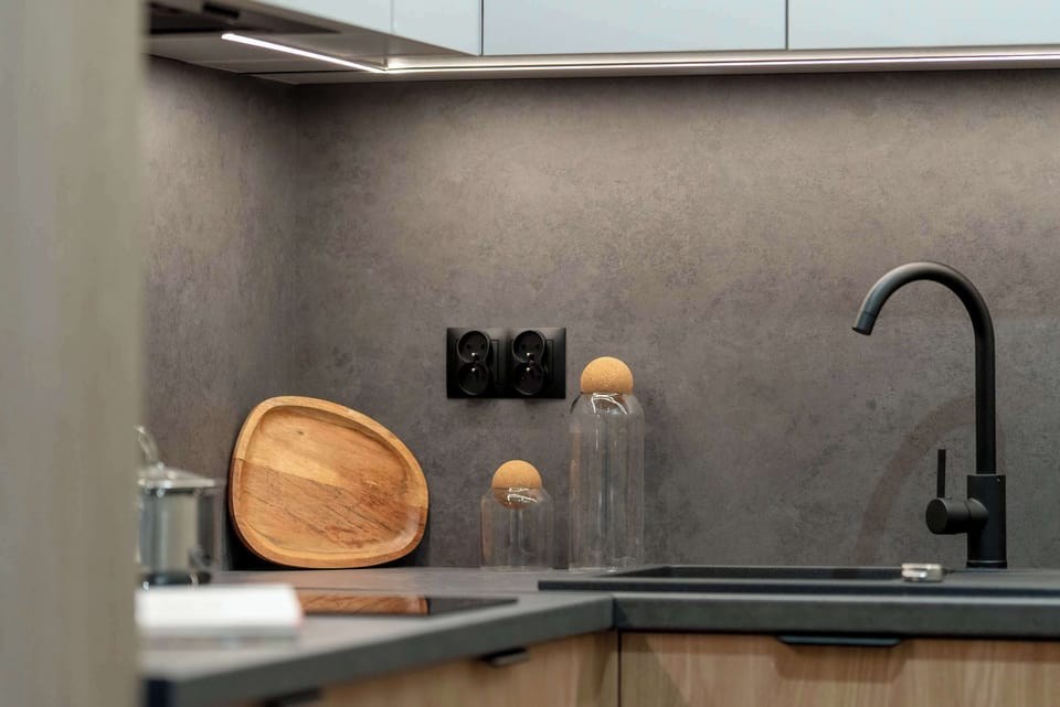 Refined kitchenette with dark countertops and minimalist accessories.