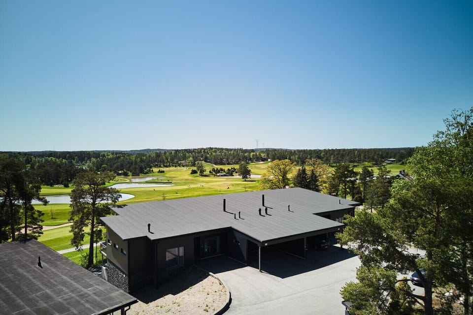 tunning aerial view of the villa nestled alongside a world-class golf course and lush forest.