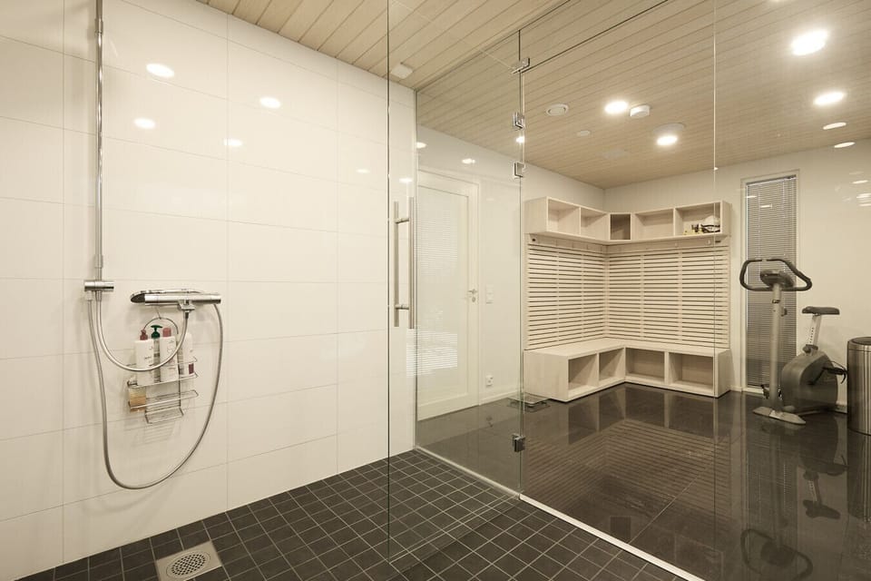 Premium spa-like bathroom with glass partitions and a contemporary changing area for ultimate comfort.