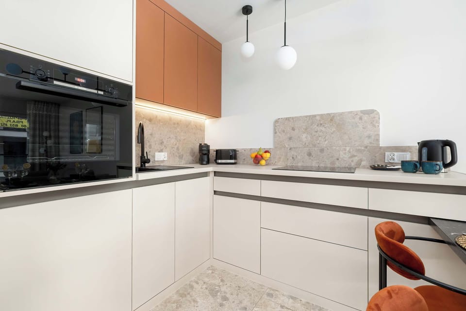 Modern open-plan kitchen with clean lines, built-in appliances, and dining table.