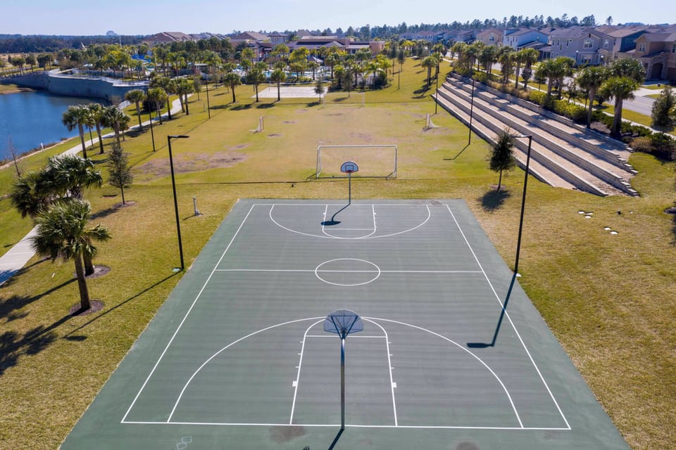 Enjoy a dynamic outdoor experience with this spacious basketball court framed by lush greenery and palm trees. The well-maintained surface invites friendly games, while the serene waterfront view enhances your active getaway.