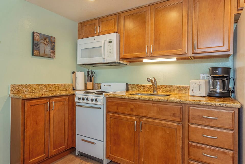 You'll love cooking in this fully equipped kitchen featuring granite countertops, warm wood cabinetry, and modern appliances.