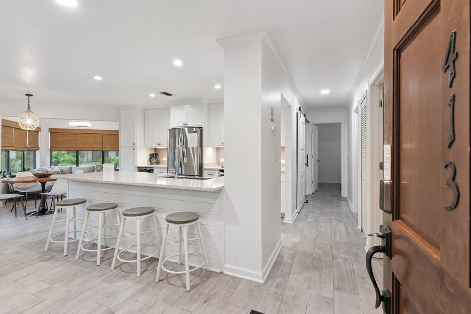Step into your bright, open kitchen with gleaming countertops, modern appliances, and bar seating perfect for morning coffee or casual meals. The adjoining dining area invites you to gather and relax in comfort.