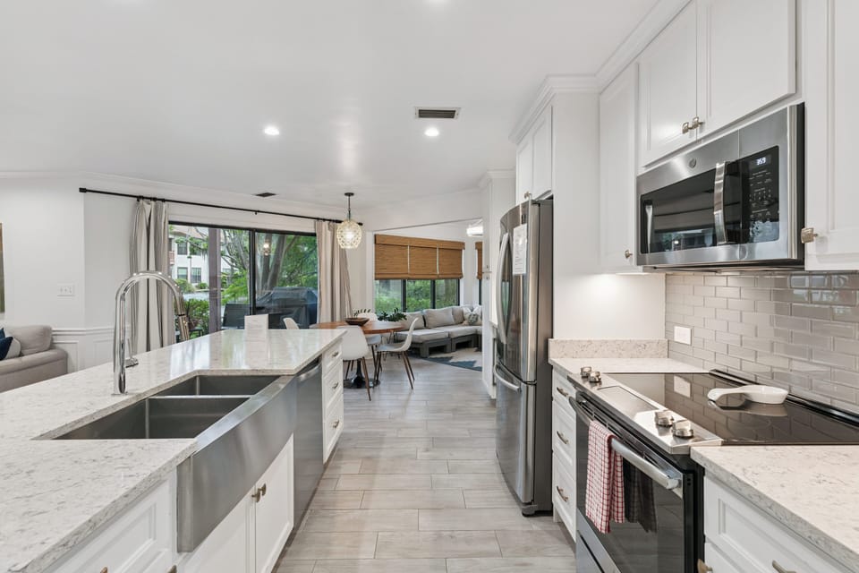 Gather around this bright, modern kitchen where every detail invites your culinary creativity. Pristine countertops, stainless steel appliances, and an open flow to the living space make cooking feel effortless and connected.