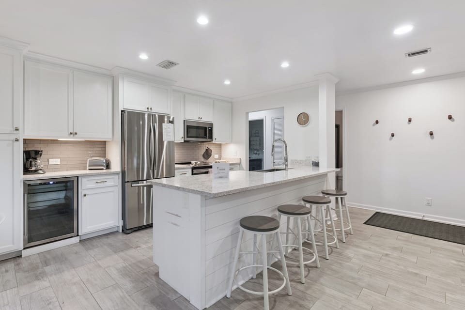 Step into your bright, modern kitchen with sleek white cabinetry, granite counters, and stainless-steel appliances. The spacious island invites you to gather for morning coffee or casual meals with friends and family.