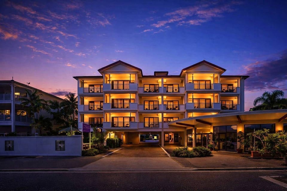Resort-style apartment building at sunset, offering a welcoming and secure stay close to the marina.