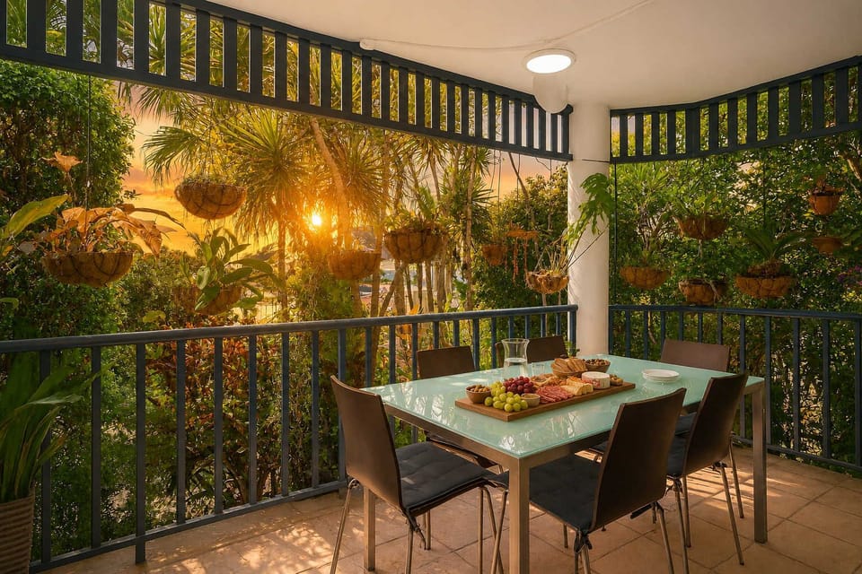 The balcony is enveloped by mature palms, hanging plants, and dense greenery, creating a private, garden-like retreat