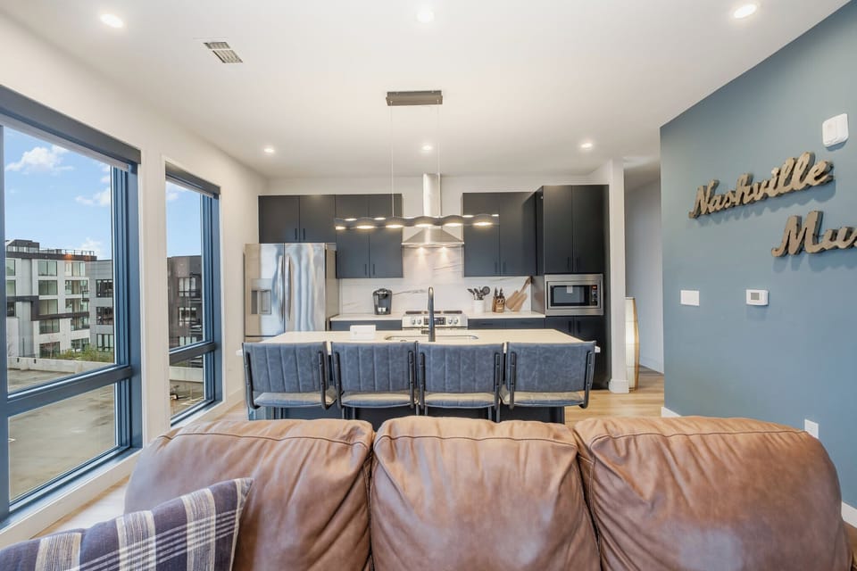 Modern open concept living. Leather sofa, Smart TV, and kitchen island seating for 4.