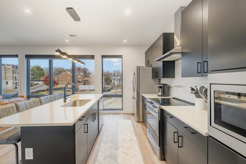 Sleek, modern kitchen with large island for dining and easy access to the living area.