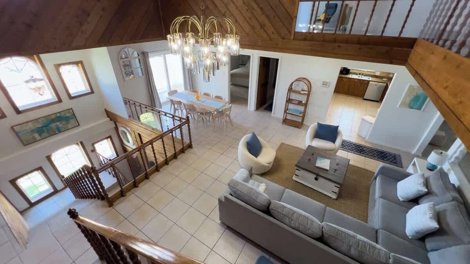 Enjoy breathtaking views of the open-concept great room from this charming upstairs retreat. Featuring vaulted wood ceilings, a sparkling chandelier, and easy access to the dining area, it’s perfect for intimate moments or lively group gatherings.