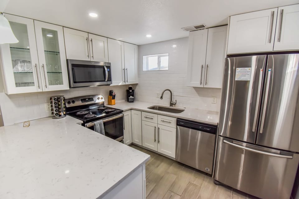 The kitchen features a sleek, modern design with premium appliances, generous counter space, and all the essentials for easy meal preparation. A perfect blend of style and functionality for cooking and gathering.