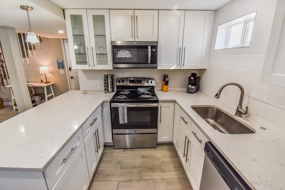 The kitchen boasts a modern design with high-quality appliances, ample counter space, and all the essentials for effortless meal preparation. Perfect for cooking and gathering in a stylish, functional space.