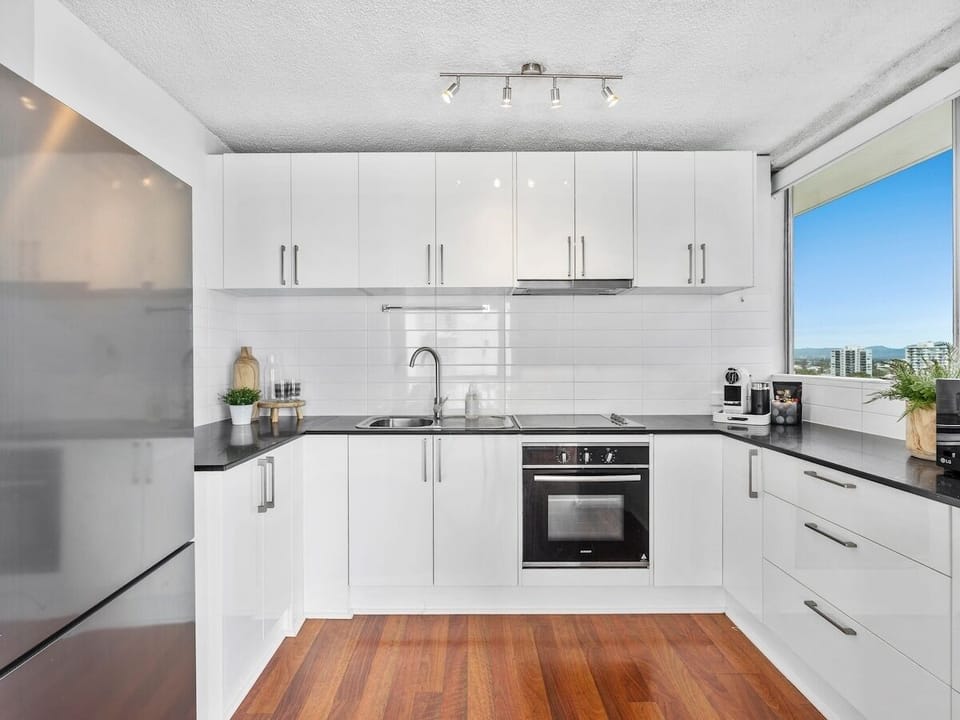 Full kitchen with fridge, oven, stovetop, microwave, Nespresso and dining setup.