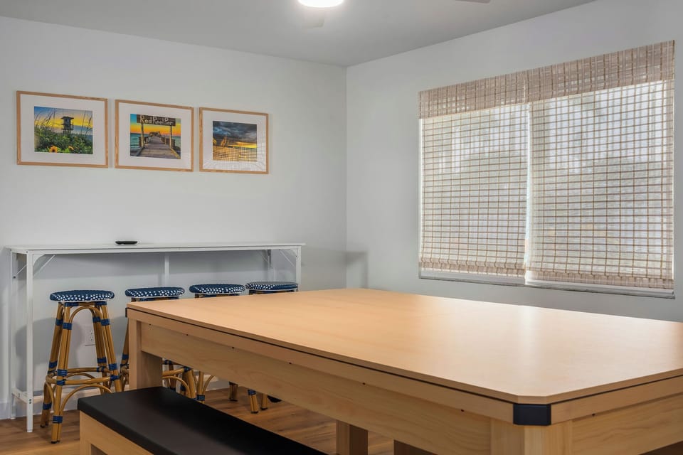 🎉 Versatile game room featuring pool, ping-pong, board games, a Smart TV, and bar seating for relaxing between games with photographs of Anna Maria Island!