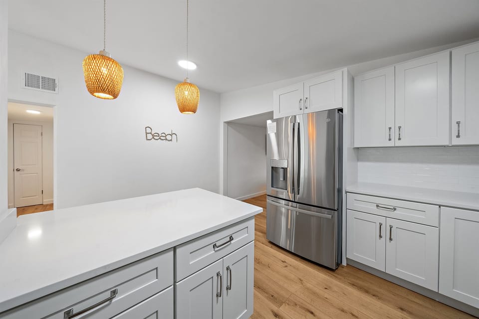 Fully stocked kitchen with new GE stainless steel appliances, a large refrigerator, a modern oven with built-in air fryer, and a deep sink with a retractable faucet— perfect for preparing home-cooked meals!