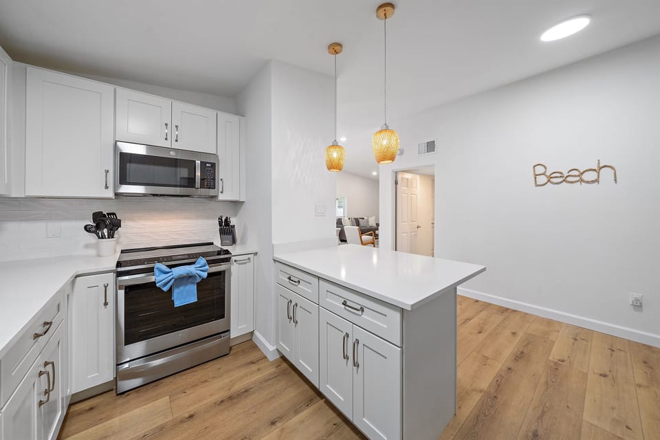 Fully stocked kitchen with new GE stainless steel appliances, a large refrigerator, a modern oven with built-in air fryer, and a deep sink with a retractable faucet— perfect for preparing home-cooked meals!