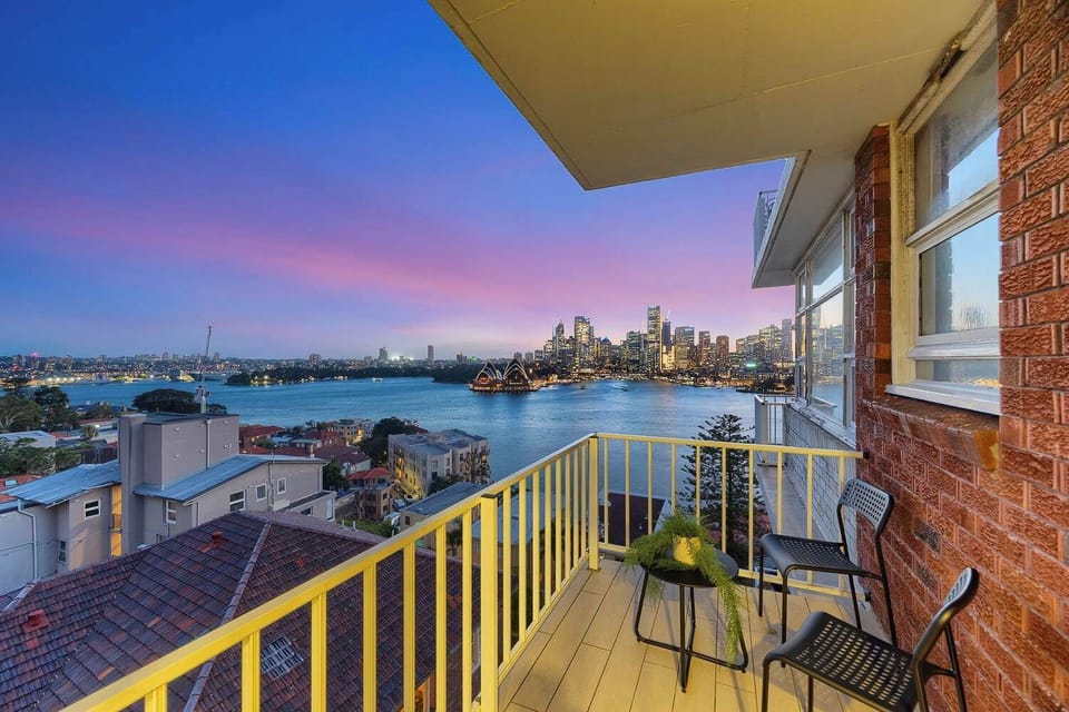 Private balcony with outdoor seating and panoramic harbour outlook.