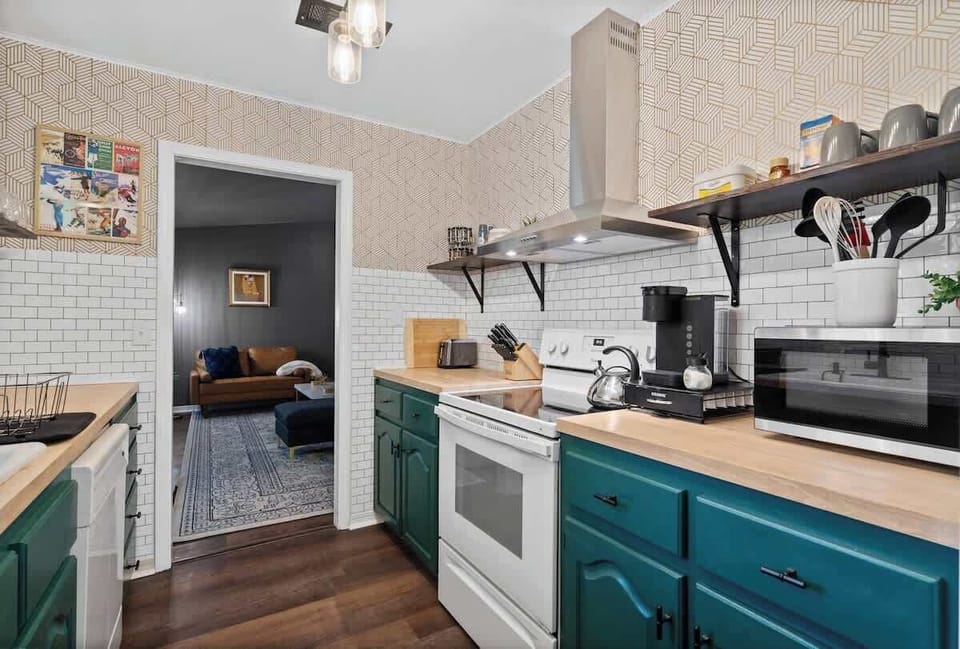 Stylish kitchen w/ teal cabinets, open shelving & plenty of space to prep meals